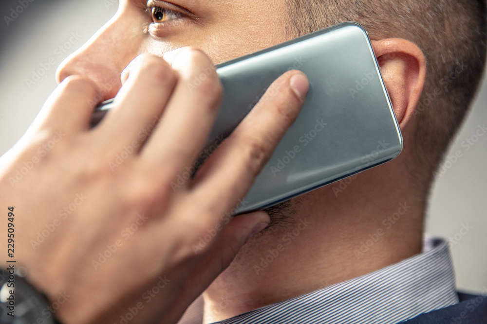 Obraz premium Elegant man is talking on the phone. Horizontal orientation of photo