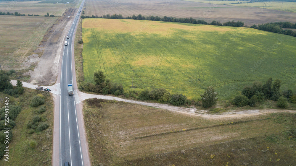 Aerial view of a road in a green field