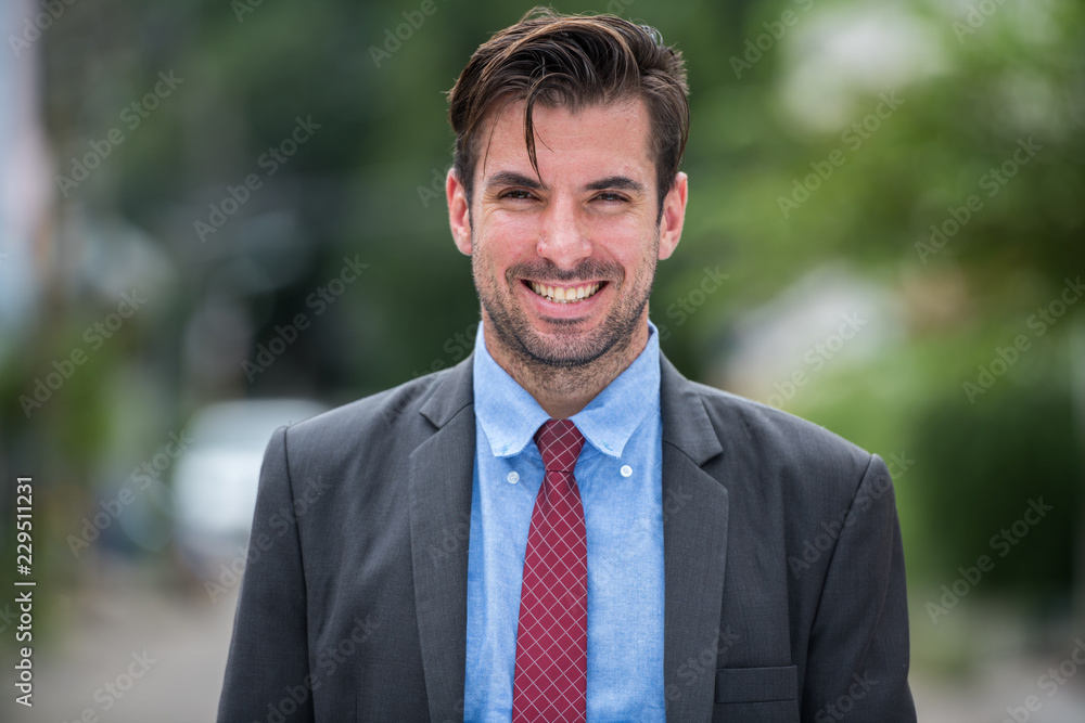 Young happy Hispanic businessman wearing suit outdoors Young happy Hispanic businessman wearing suit outdoors