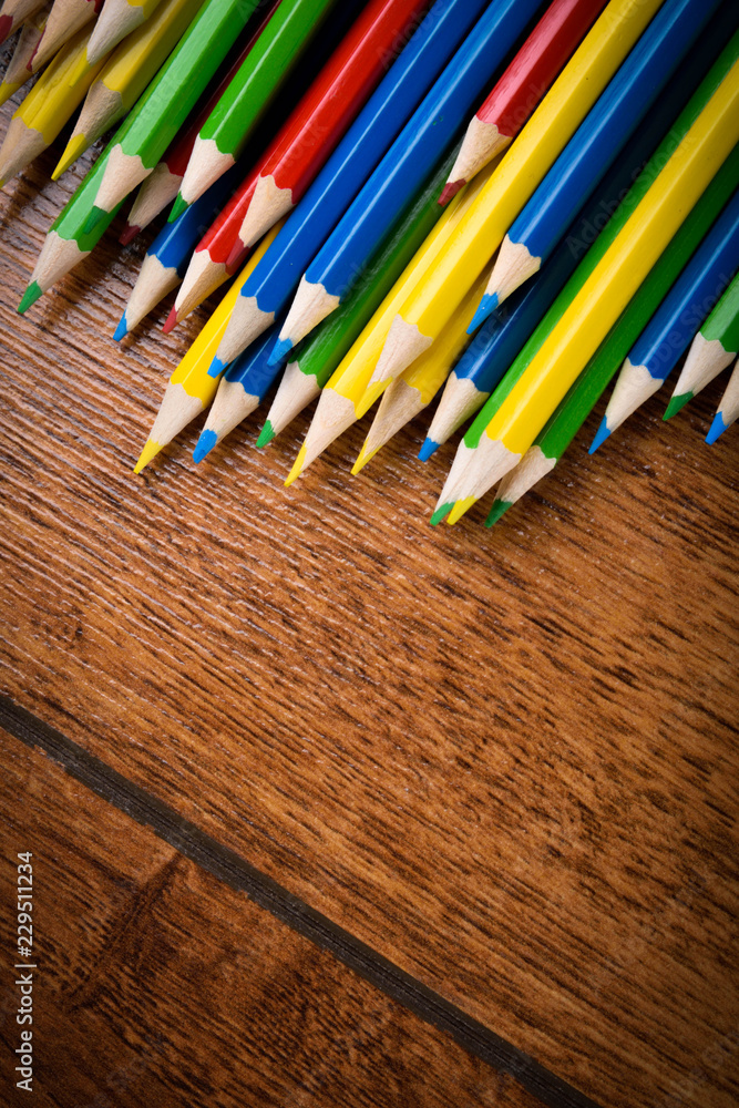 Different colored pencils on the brown wooden table background .Top view .Close up .Color .Pencil.Set Different colored pencils on the brown wooden table background .Top view .Close up .Color .Pencil.Set