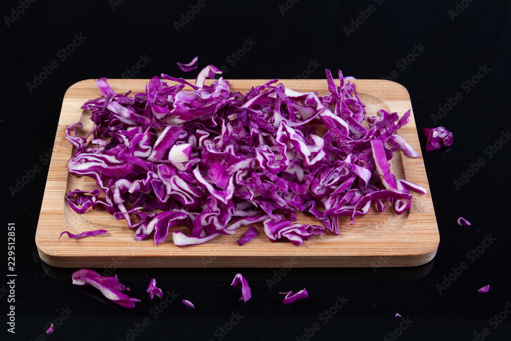 Shredded red cabbage on wooden cutting board Shredded red cabbage on wooden cutting board