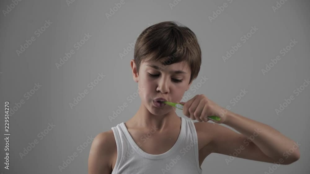Lttle boy brushing his teeth in bathroom and stop becuse of a tooth pain. Dental problems Lttle boy brushing his teeth in bathroom and stop becuse of a tooth pain. Dental problems