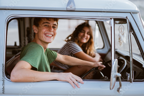 young people inside a car looking at camera © Odua Images