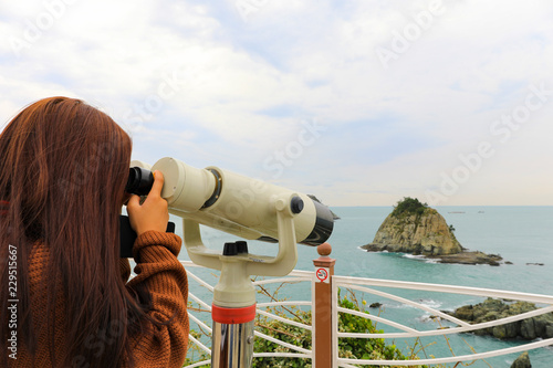 Binoculars. young girl use binocular looking to the island view at Oryukdo islands in Busan, South Korea.