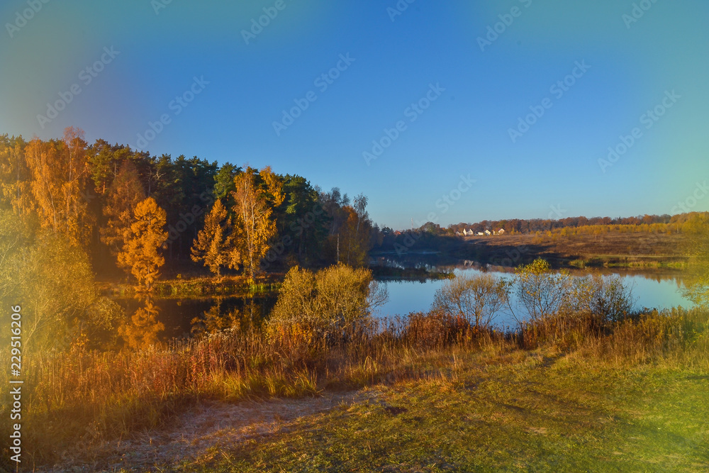 Autumn landscape with colorful forest. Colorful foliage over the lake with beautiful forests in red and yellow colors. Autumn forest is reflected in the water. old photo effect