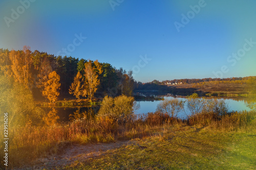 Autumn landscape with colorful forest. Colorful foliage over the lake with beautiful forests in red and yellow colors. Autumn forest is reflected in the water. old photo effect