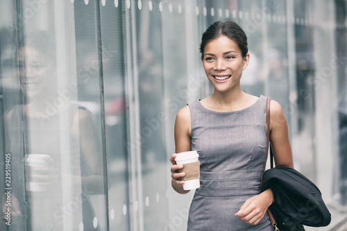 Valokuva Asian business woman walking going to work drinking coffee to Office building