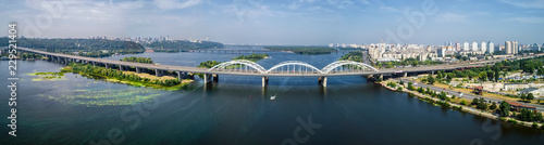Aerial panorama view of automobile and railroad Darnitsky bridge across Dnieper river from above  Kiev city skyline