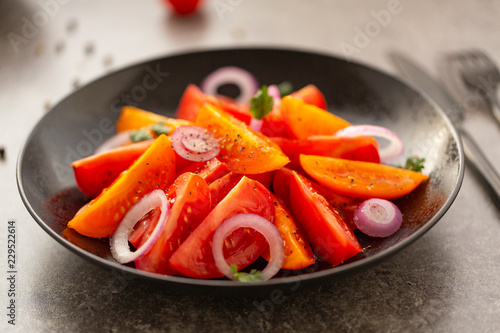 Fresh tomato salad with onion, parsley, spices and olive oil