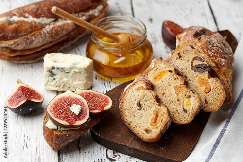Sandwich with figs, brie cheese and honey on wooden background.