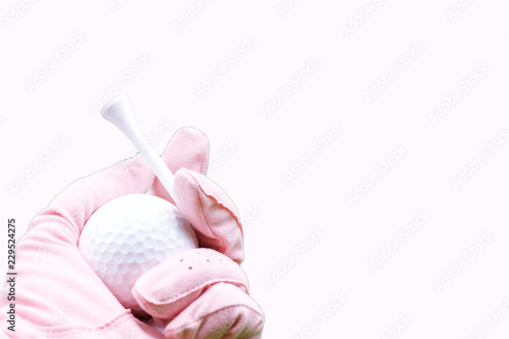 Hand of lady golfer is holding tee and golf ball Hand of lady golfer is holding tee and golf ball