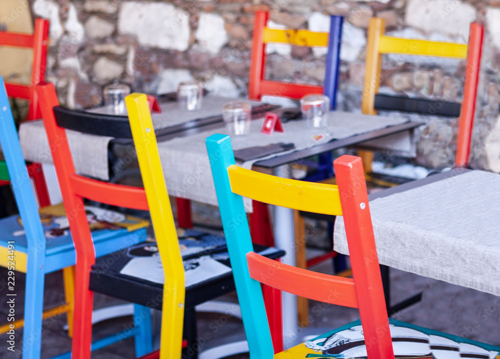 Tables with multi-colored chairs on the terrace in a cafe in Taormina, Sicily, Italy