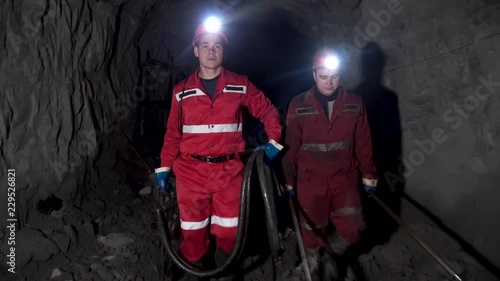Workers in mine perforating the rock using a pneumatic drill