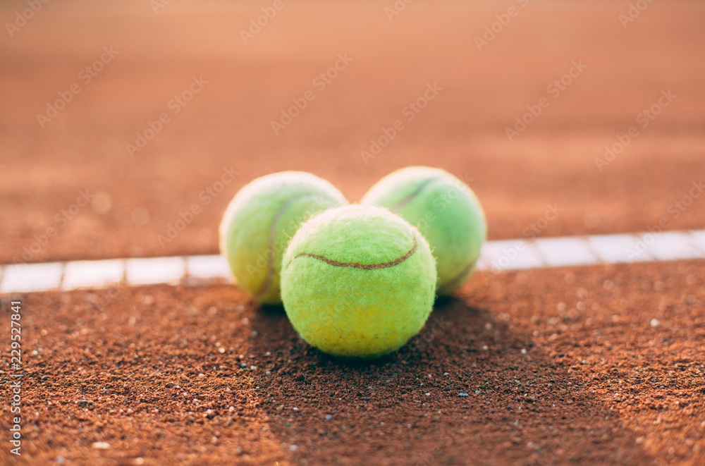 Tennis balls on clay court.	