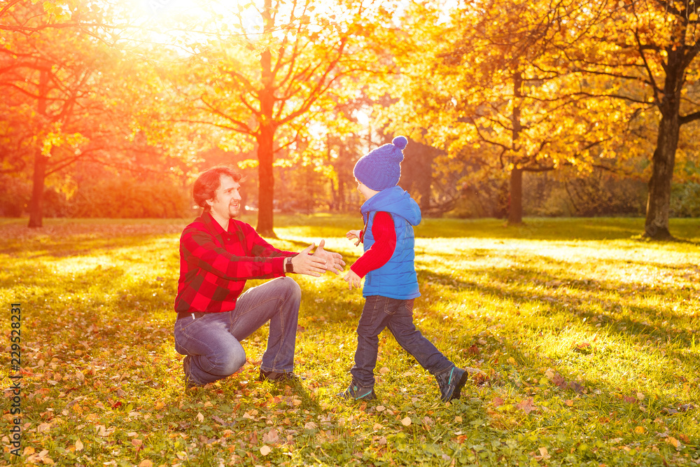 Father walks with his son in the autumn park. A child and a man in the forest are having fun on a walk. Family spends time in nature Father walks with his son in the autumn park. A child and a man in the forest are having fun on a walk. Family spends time in nature