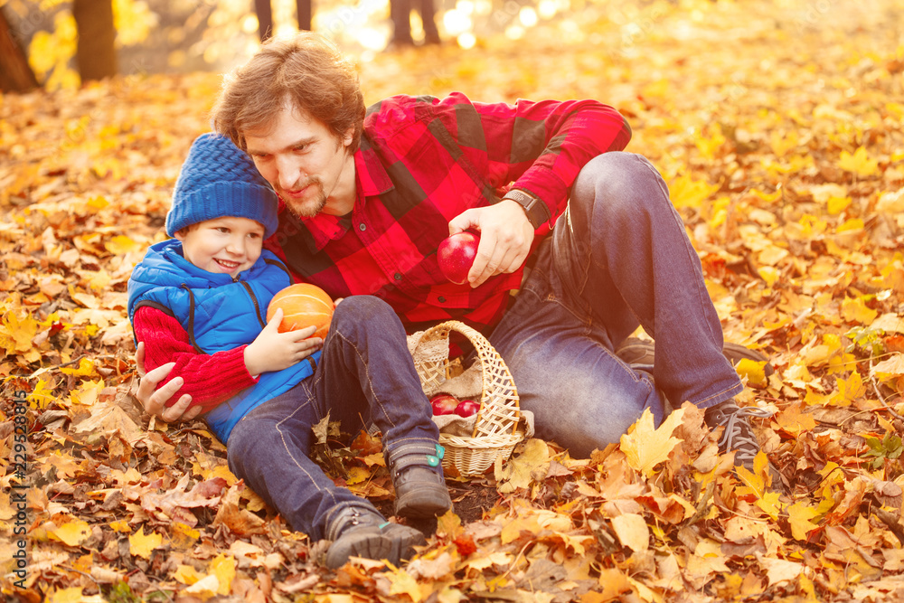 Father walks with his son in the autumn park. A child and a man in the forest are having fun on a walk. Family spends time in nature Father walks with his son in the autumn park. A child and a man in the forest are having fun on a walk. Family spends time in nature