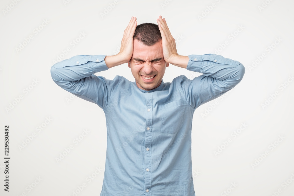 Rrustrated and depressed man clenches teeth in pain, suffers from ache, closes eyes Rrustrated and depressed man clenches teeth in pain, suffers from ache, closes eyes