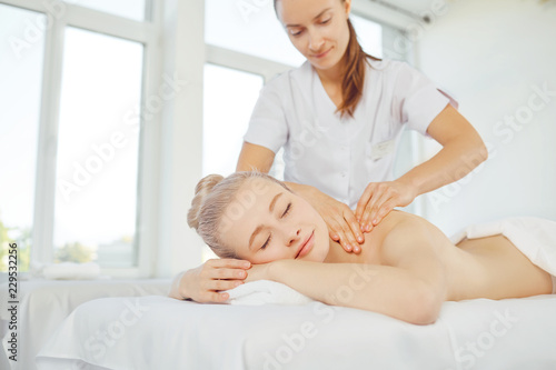 Body massage. Beautiful blond woman in spa salon doing body massage.