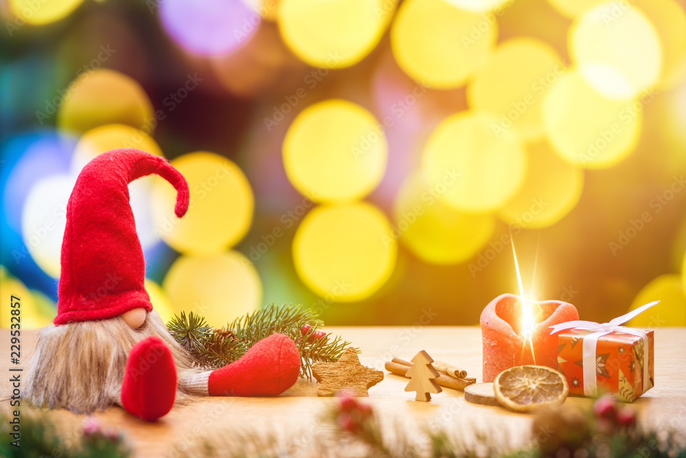 Εκτύπωση καμβά Christmas dwarf with bokeh lights in background and fir branch with ignited adve