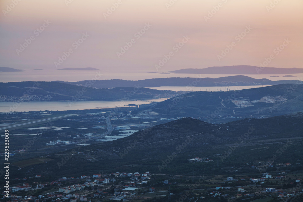 Top view of small city and islands layered with mist after sunset