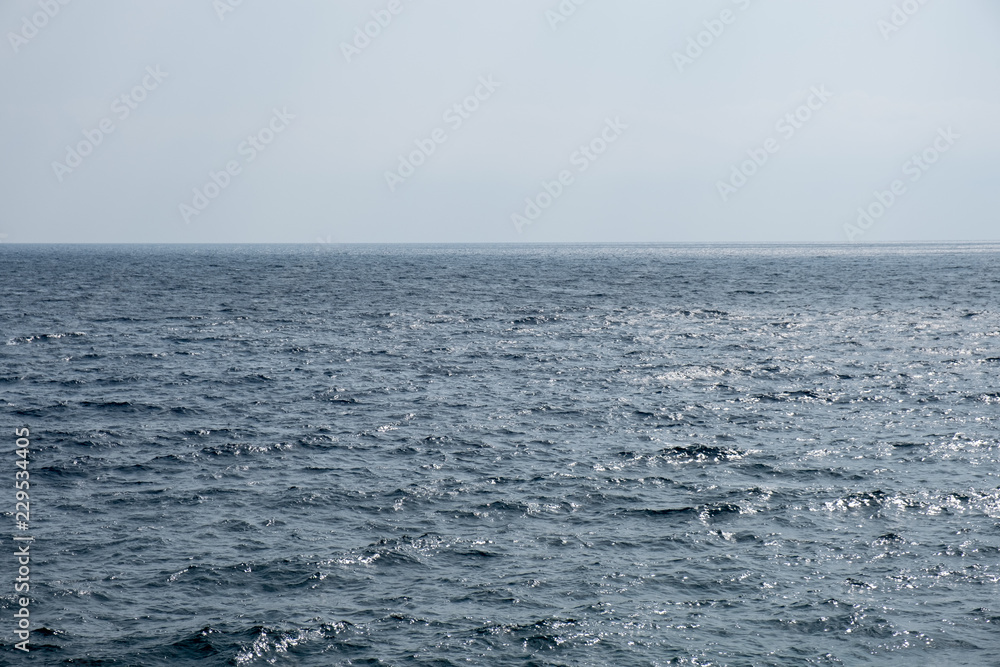 Deep blue surface of a calm sea merging with the empty sky Deep blue surface of a calm sea merging with the empty sky