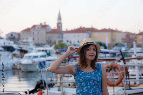 Europe summer travel mediterranean destination. Tourist woman on vacation, walking on the streets of old and beautiful Mediterranean city in hat and summer dress © Nickolay Khoroshkov