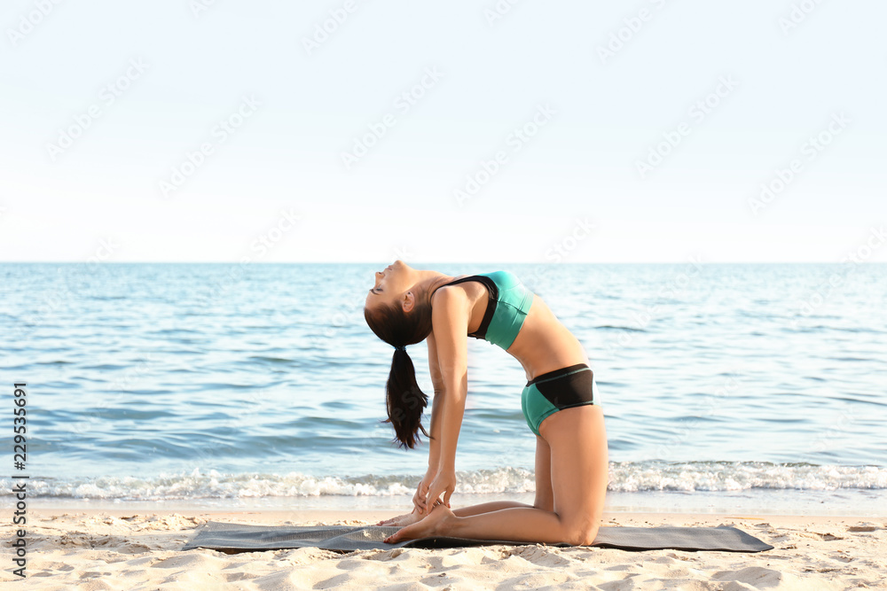 Woman practicing yoga on sea shore Woman practicing yoga on sea shore