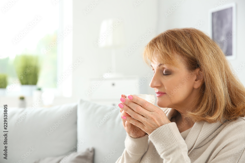 Beautiful mature woman drinking coffee at home