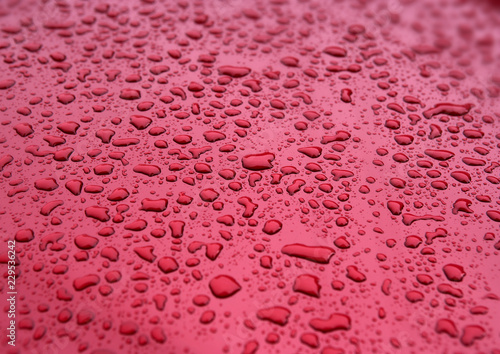 WATER DROPLETS ON RED SURFACE