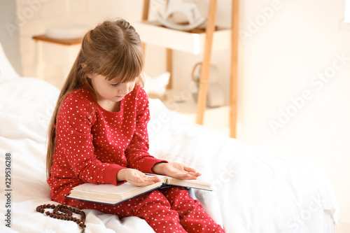 Little girl with Bible pray...