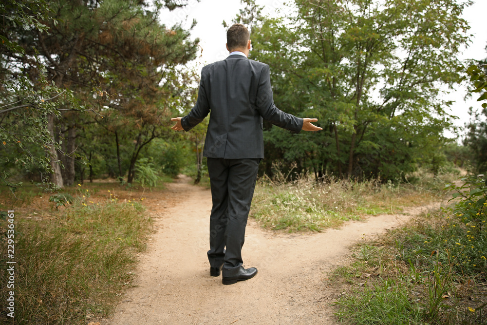 Confused businessman standing at crossroads. Concept of choice Confused businessman standing at crossroads. Concept of choice