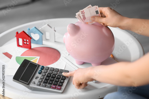 Woman putting money into pi...