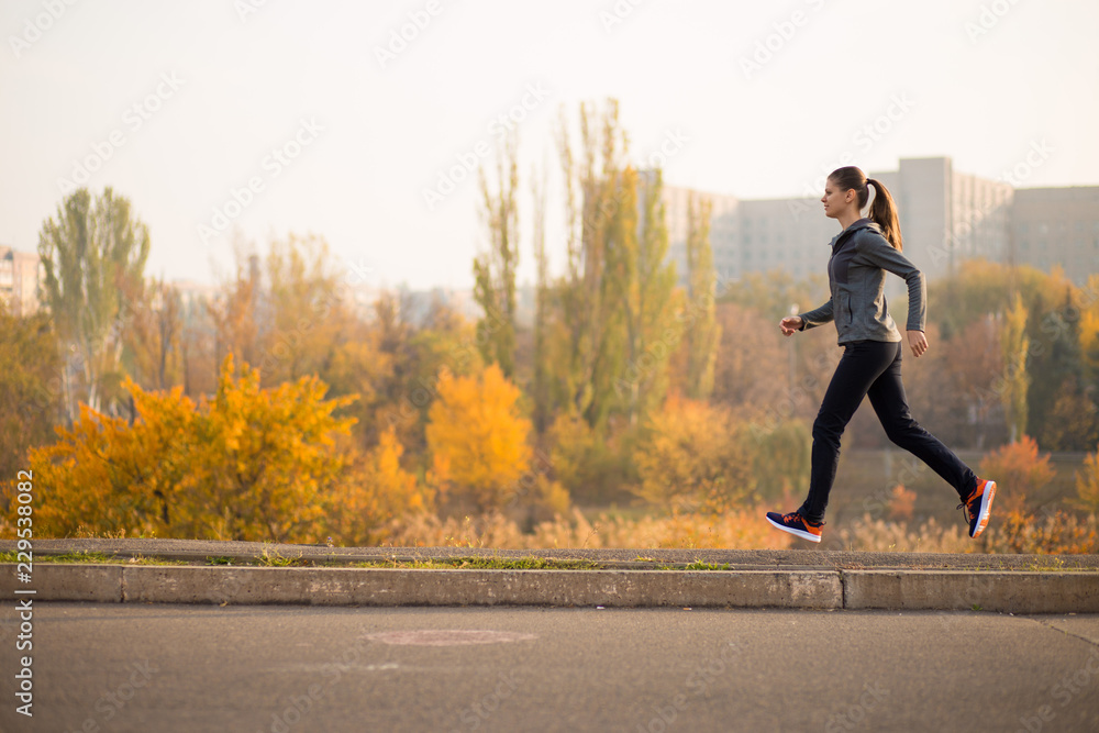 Woman running in autumn fall forest. Healthy lifestyle Woman running in autumn fall forest. Healthy lifestyle