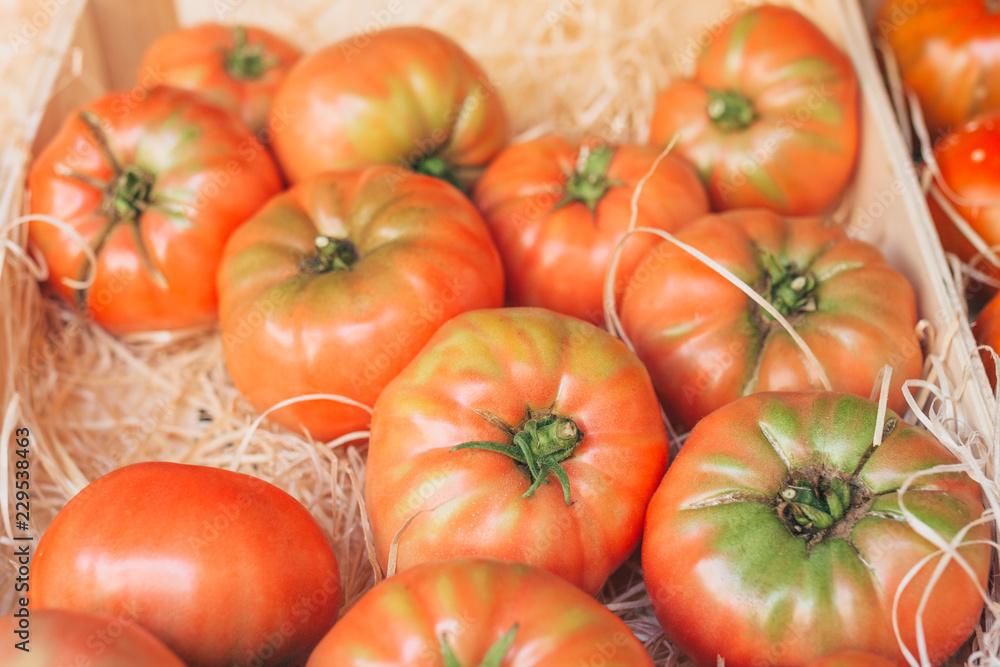 Large juicy tomatoes in a box on the market