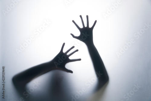 Shadow hands of the woman behind the white curtain