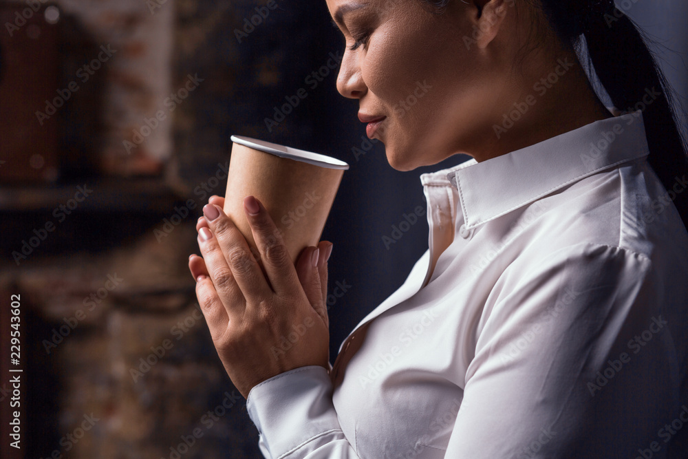 Portrait of businesswoman having coffee. Isolated on dark background. Portrait of businesswoman having coffee. Isolated on dark background.