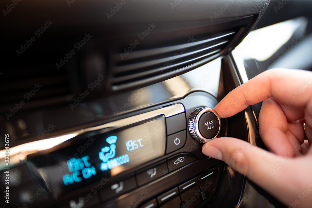 Man turning on car air conditioning system