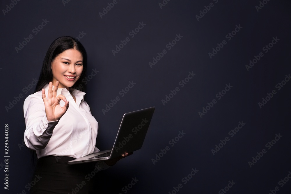 Smiling business woman posing on camera and holding laptop. Woman in business concept. Smiling business woman posing on camera and holding laptop. Woman in business concept.