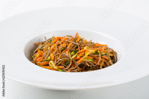 Buckwheat spaghetti with vegetables in white dish