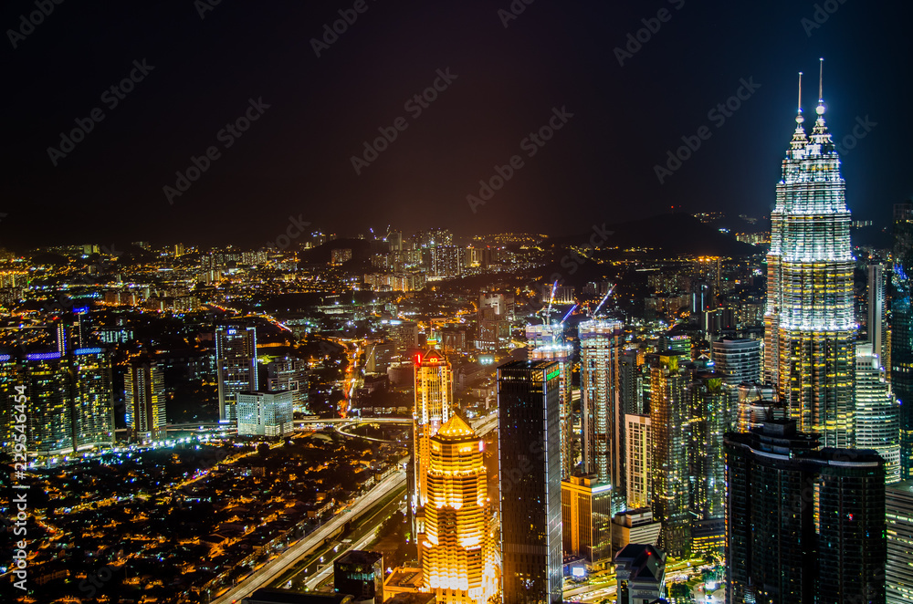 Fototapeta premium Słynne drapacze chmur Petronas Twin Towers Kuala Lumpur, Malezja. Widok z lotu ptaka w nocy