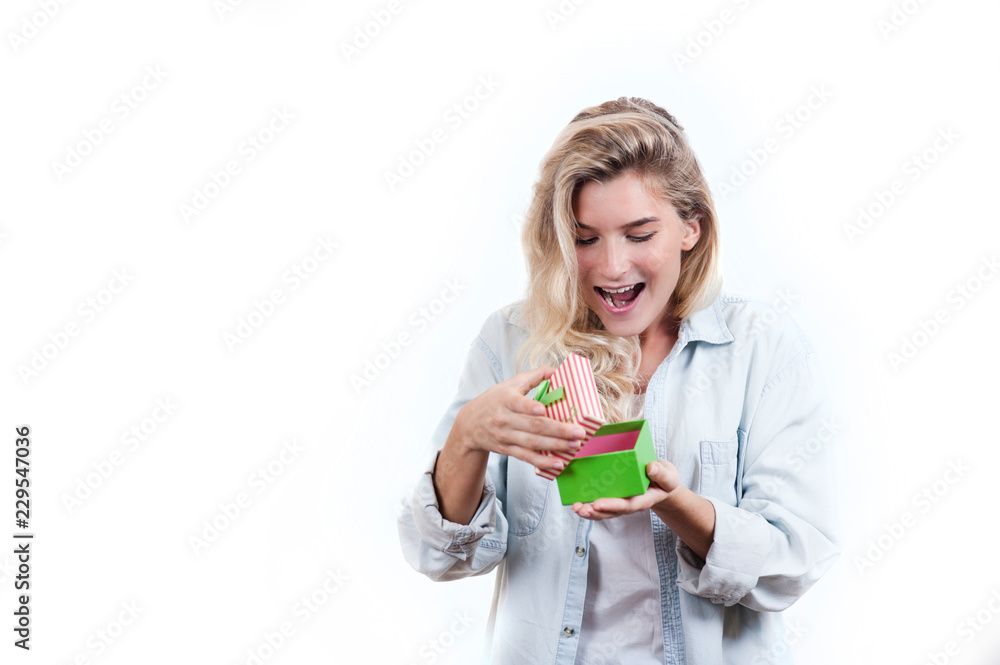 a very beautiful young emotional girl rejoices at the received gift and screams with happiness on a white isolated background a very beautiful young emotional girl rejoices at the received gift and screams with happiness on a white isolated background