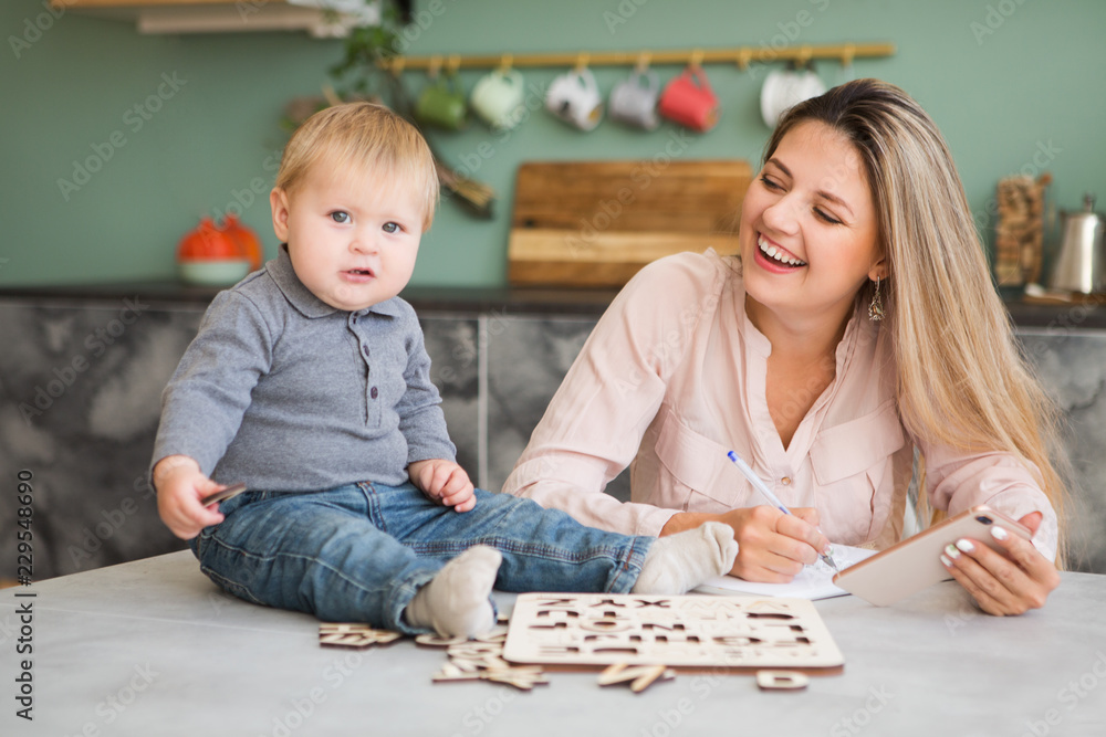 Young mother working and playing with her child from home. Young mother working and playing with her child from home.