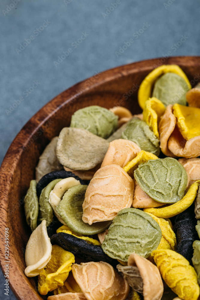 Traditional Italian Rainbow pasta. Colored raw pasta on a stone background Traditional Italian Rainbow pasta. Colored raw pasta on a stone background