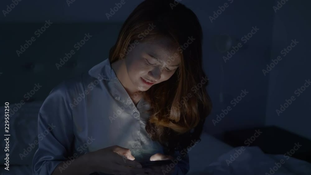 Beautiful asian woman in sleepwear are using the smart phone on the bed in the before sleeping at night. Beautiful asian woman in sleepwear are using the smart phone on the bed in the before sleeping at night.