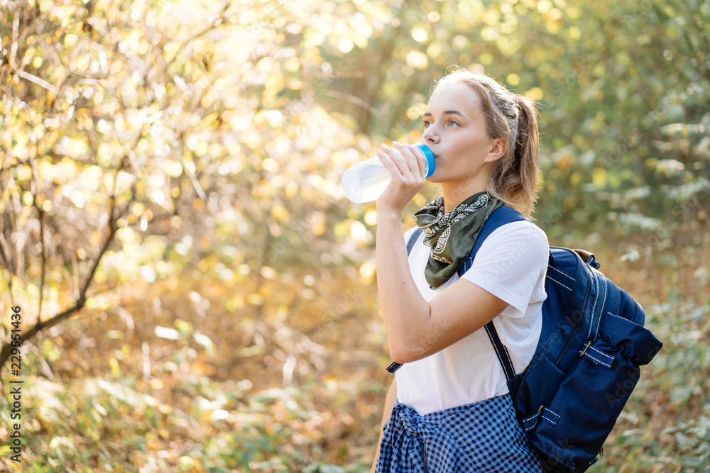 Young beautiful woman drinking water in sport bottle on hiking Young beautiful woman drinking water in sport bottle on hiking