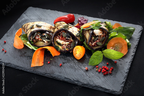 Warzywne roladki. Roladki z grillowanego bakłażana z suszonymi pomidorami i serem podane na sałacie i marchewce.