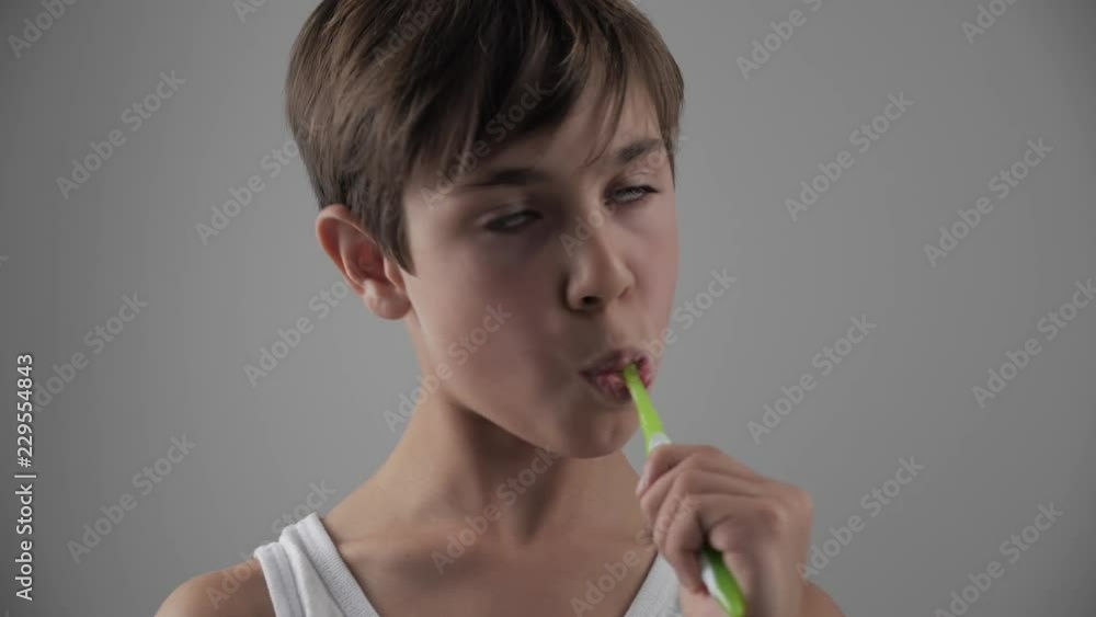 Lttle boy brushing his teeth in bathroom and stop becuse of a tooth pain. Dental problems Lttle boy brushing his teeth in bathroom and stop becuse of a tooth pain. Dental problems