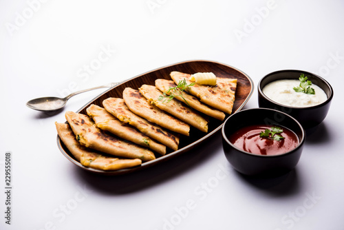 Aloo Paratha / Indian Potato stuffed Flatbread. Served with fresh curd and tomato ketchup. selective focus photo