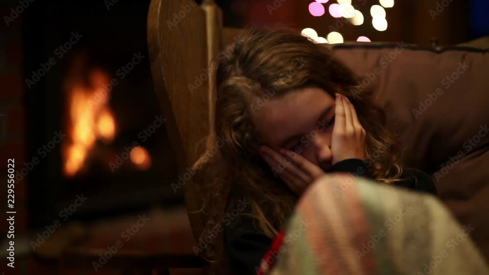 teenager sleeps with a warm fireplace on a winter evening teenager sleeps with a warm fireplace on a winter evening