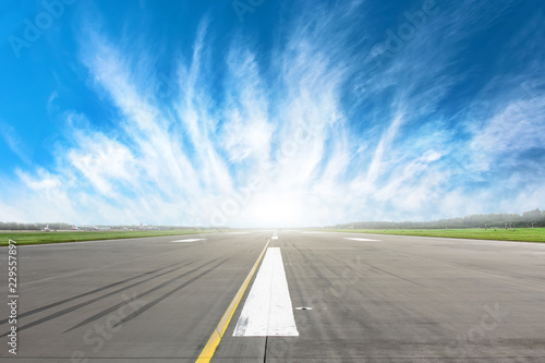 Empty runway strip with markings with beautiful clouds on the horizon.